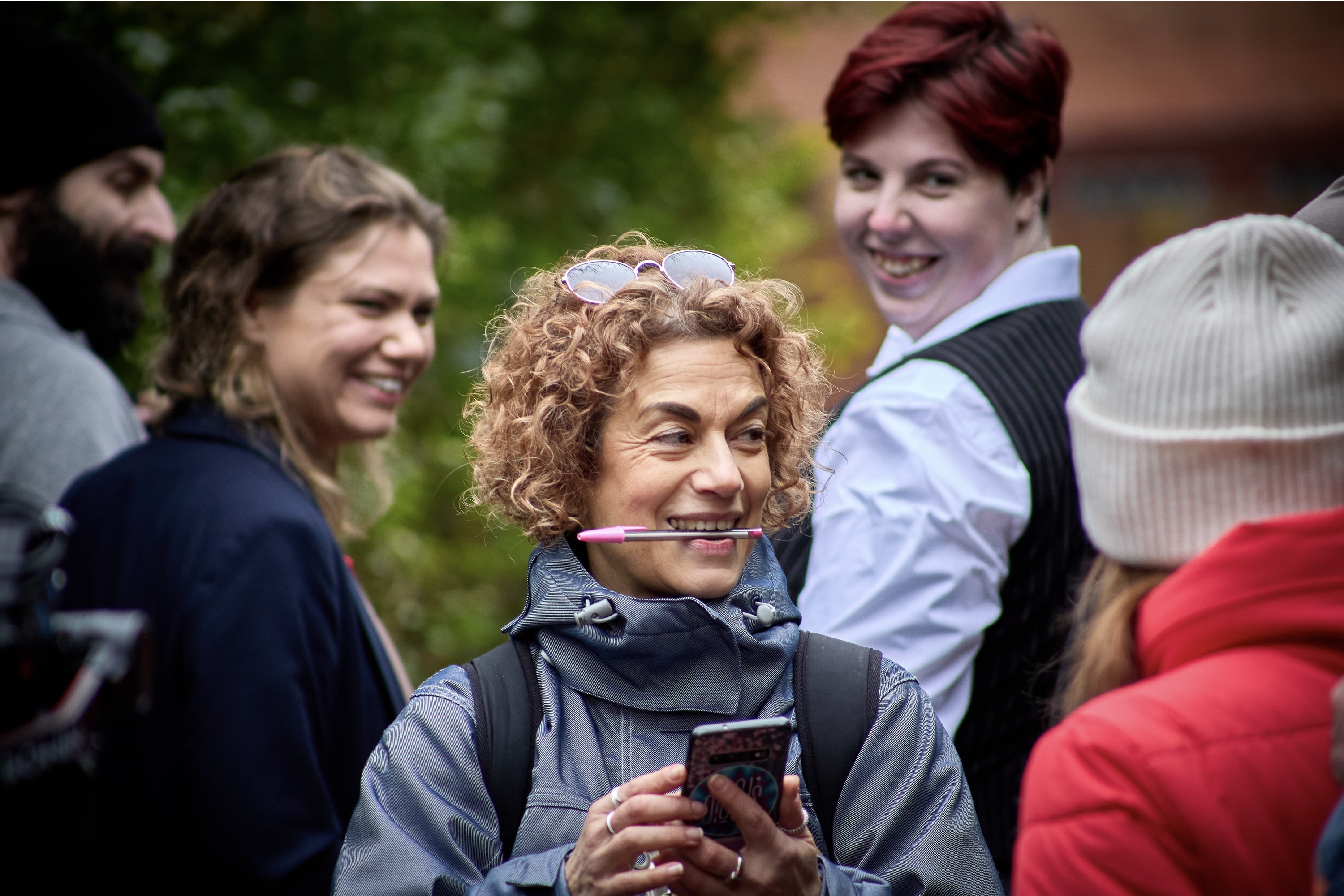 Back of a man at a concert. Hes wearing a beanie hat and a baggy denim jacket with studs. Photo with a purple hue